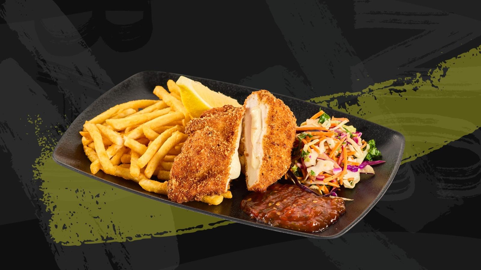 Toit mustal taldrikul: paneeritud kana, friikartulid, coleslaw salat ja BBQ kaste. Sidruniviil äärel.