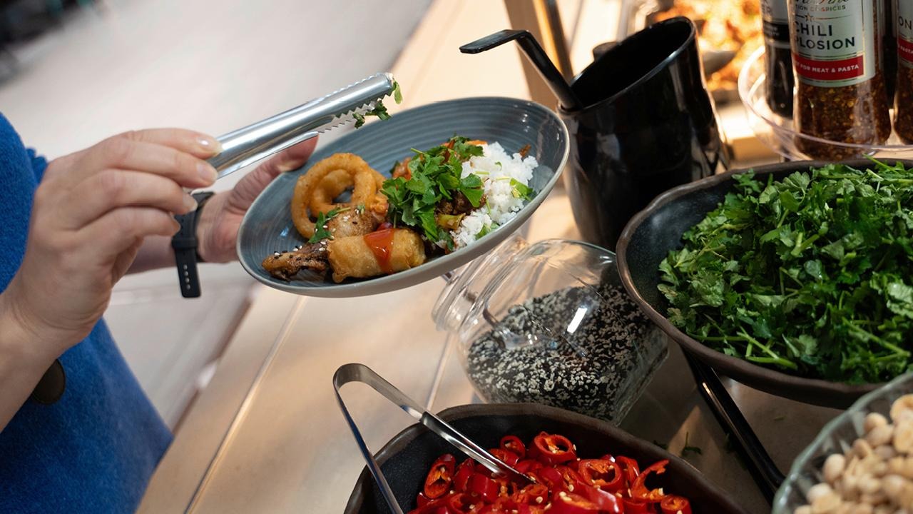 Asiakas maustaa wokkiannostaan korianterilla.