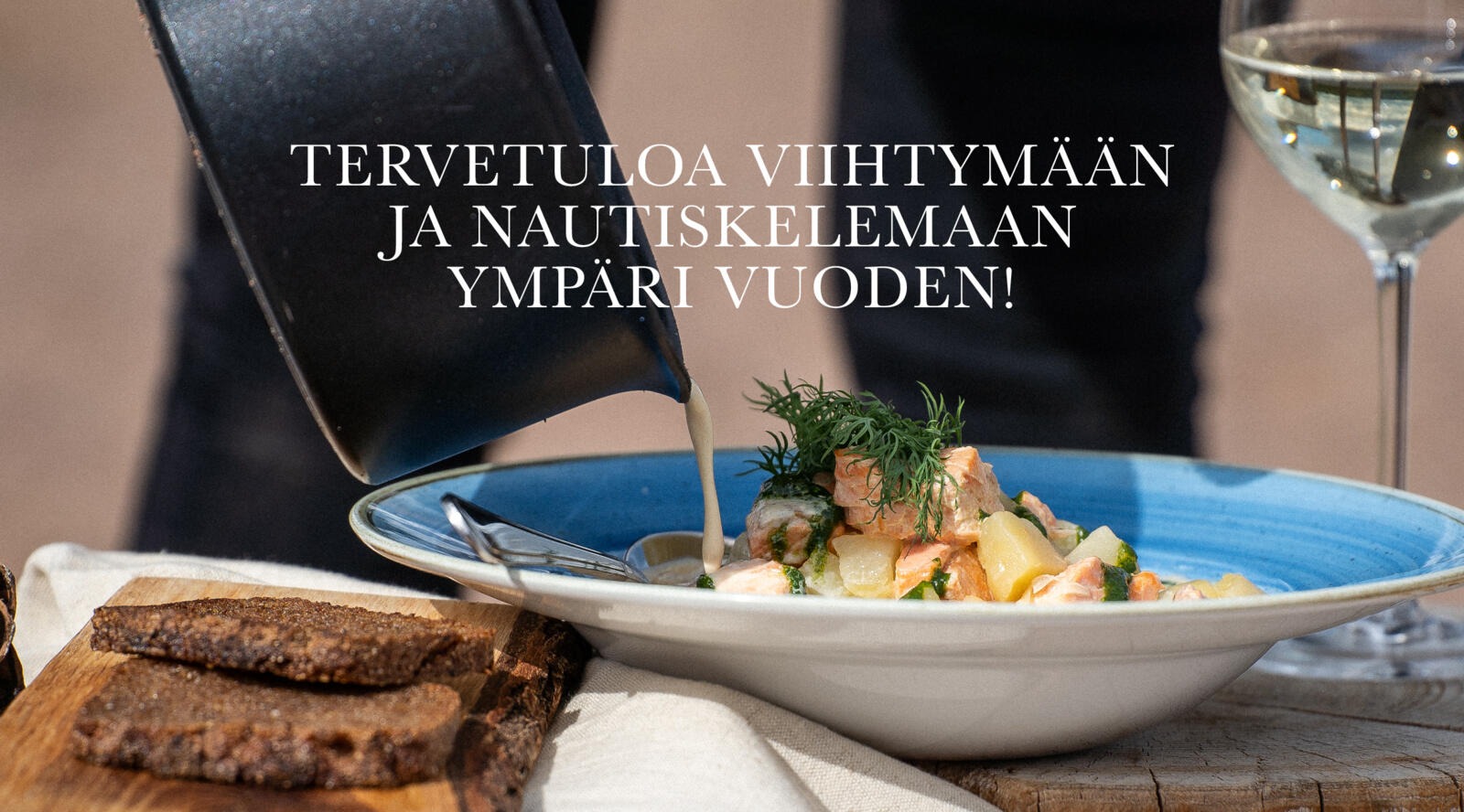 Kermaista lohikeittoa kaadetaan kattilasta siniselle lautaselle.