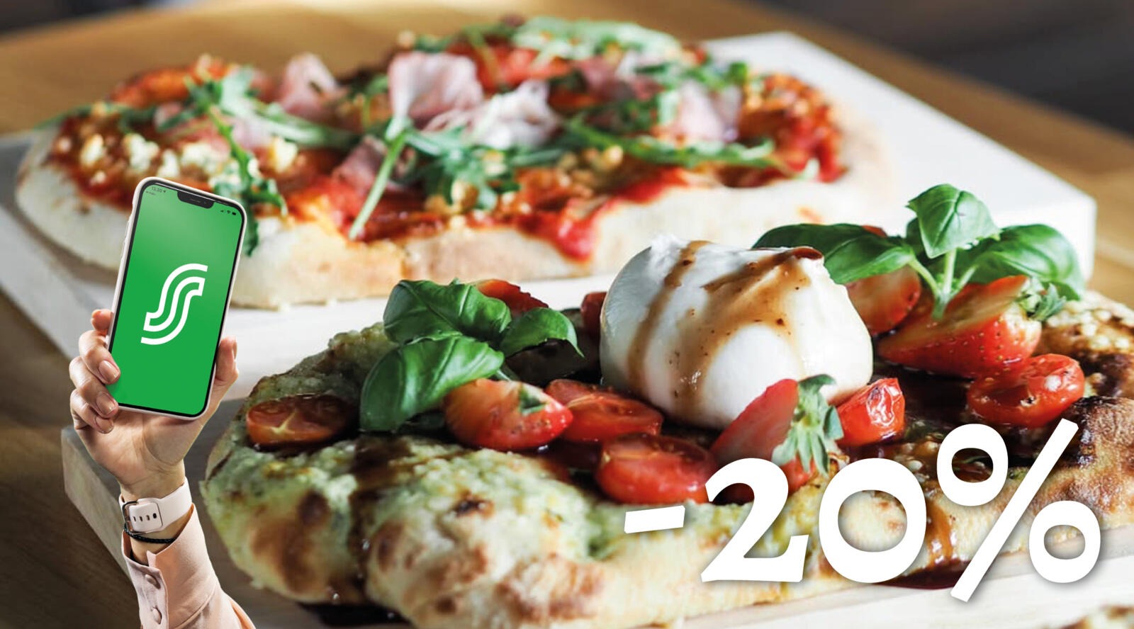 Käsi hoiab telefoni, taustal valgel taldrikul pitsa ja röstitud leib mozzarella, tomatite ja roheliste salatilehtedega.