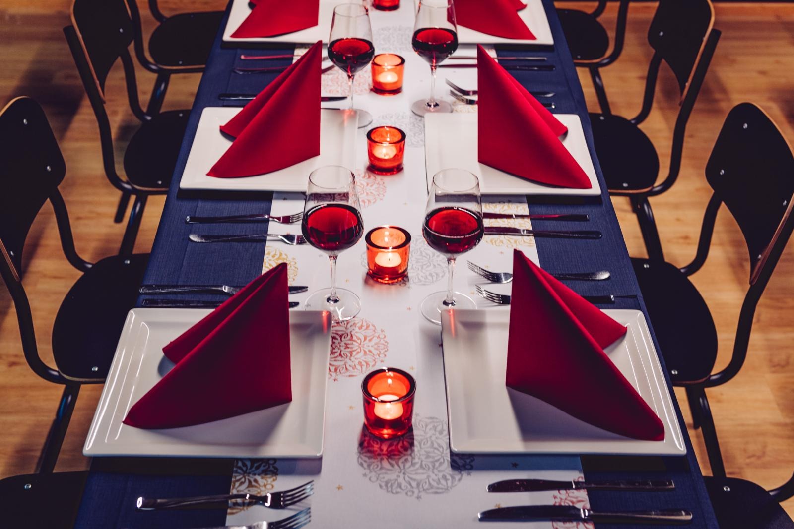 Pitkä pöytä valmiiksi katettuna.