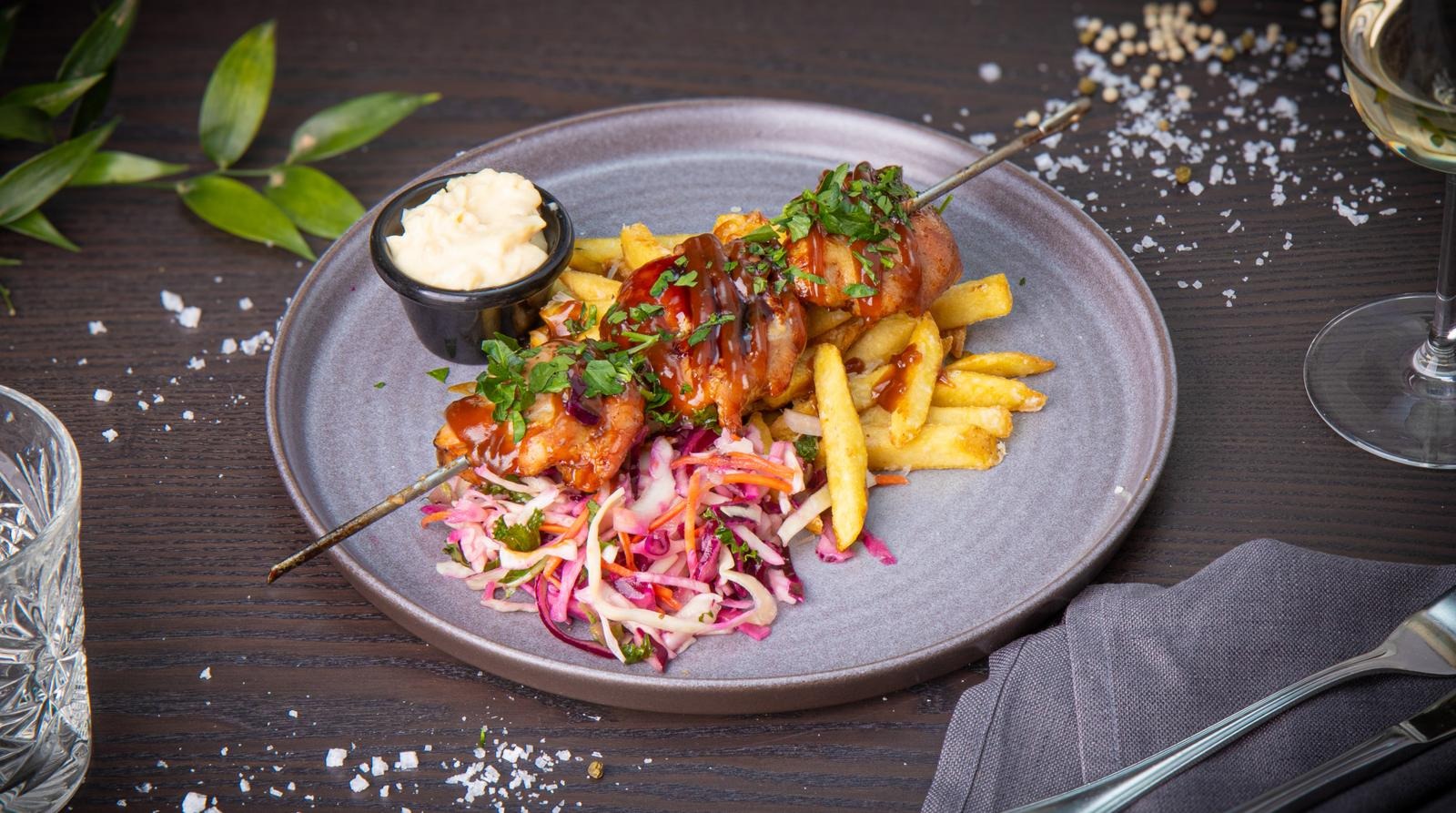 Charcoal-grilled chicken skewer, BBQ-sauce flavored with Jaloviina, coleslaw, Mustakari’s country fries with Parmesan cheese and lemon aioli