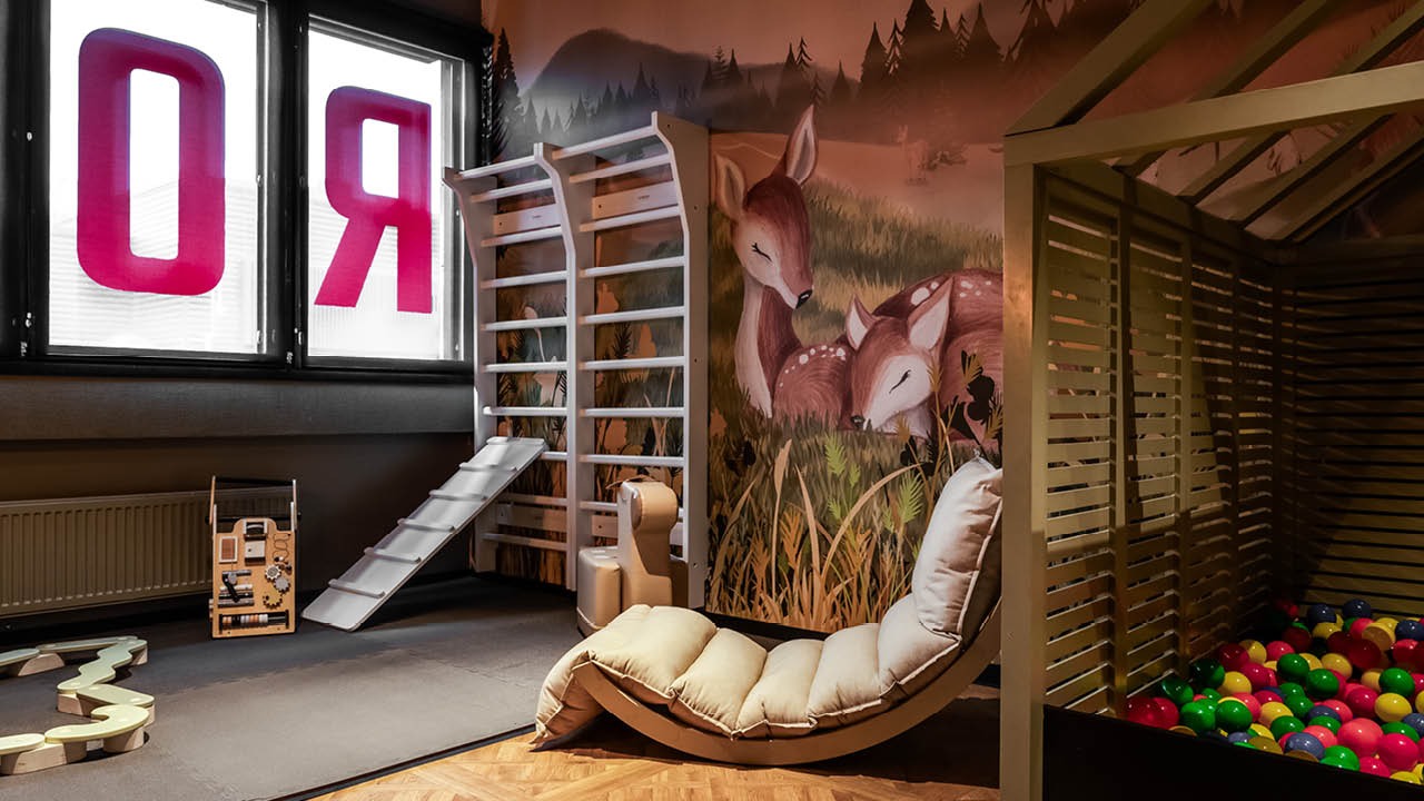 Rosson lasten leikkinurkkaus, jossa on pallomeri, puolapuut ja leluja.