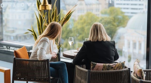Kaksi naista ihailemassa kuohuviinin kera Walo Rooftop Barissa näkymiä Turun kattojen ylle