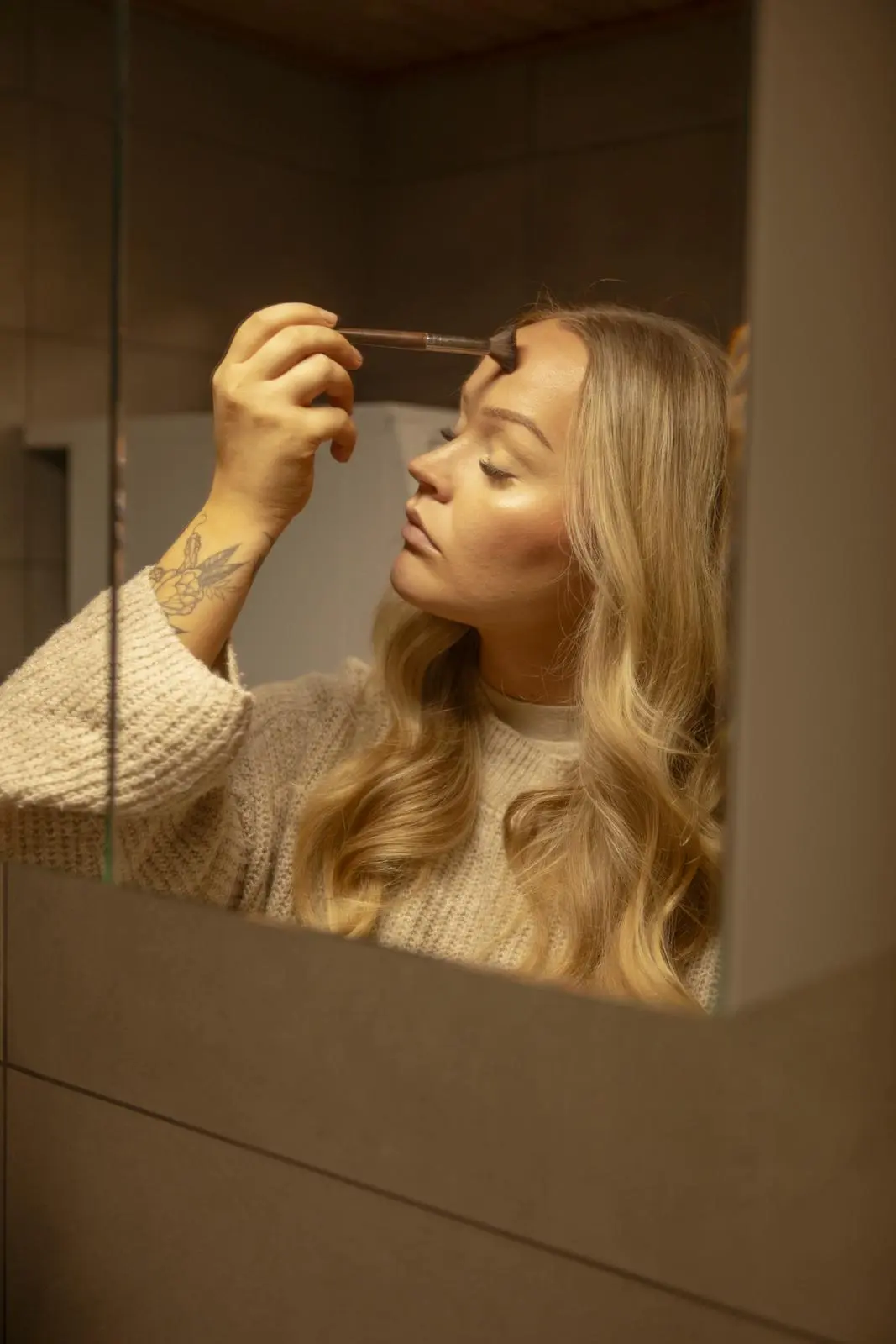 Emilia Tukiainen meikkaa kylpyhuoneen peilin ääressä