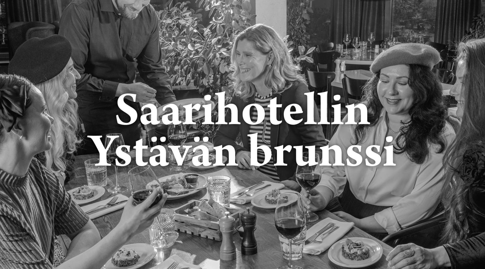 Mustavalkoinen kuva iloisesta naisryhmästä ruuan ja viinin parissa ranskalaisessa ravintolassa.