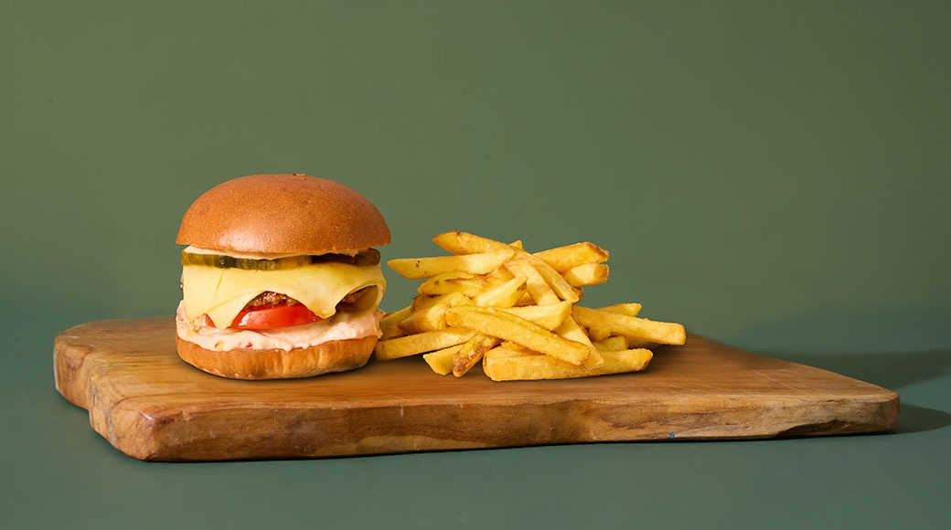 Briossisämpylä, burgerpihvi, Monterey Jack -juustoa, talon American-majoneesia, tomaattia, sipulia ja maustekurkkua. Tarjoillaan ranskalaisten kera.