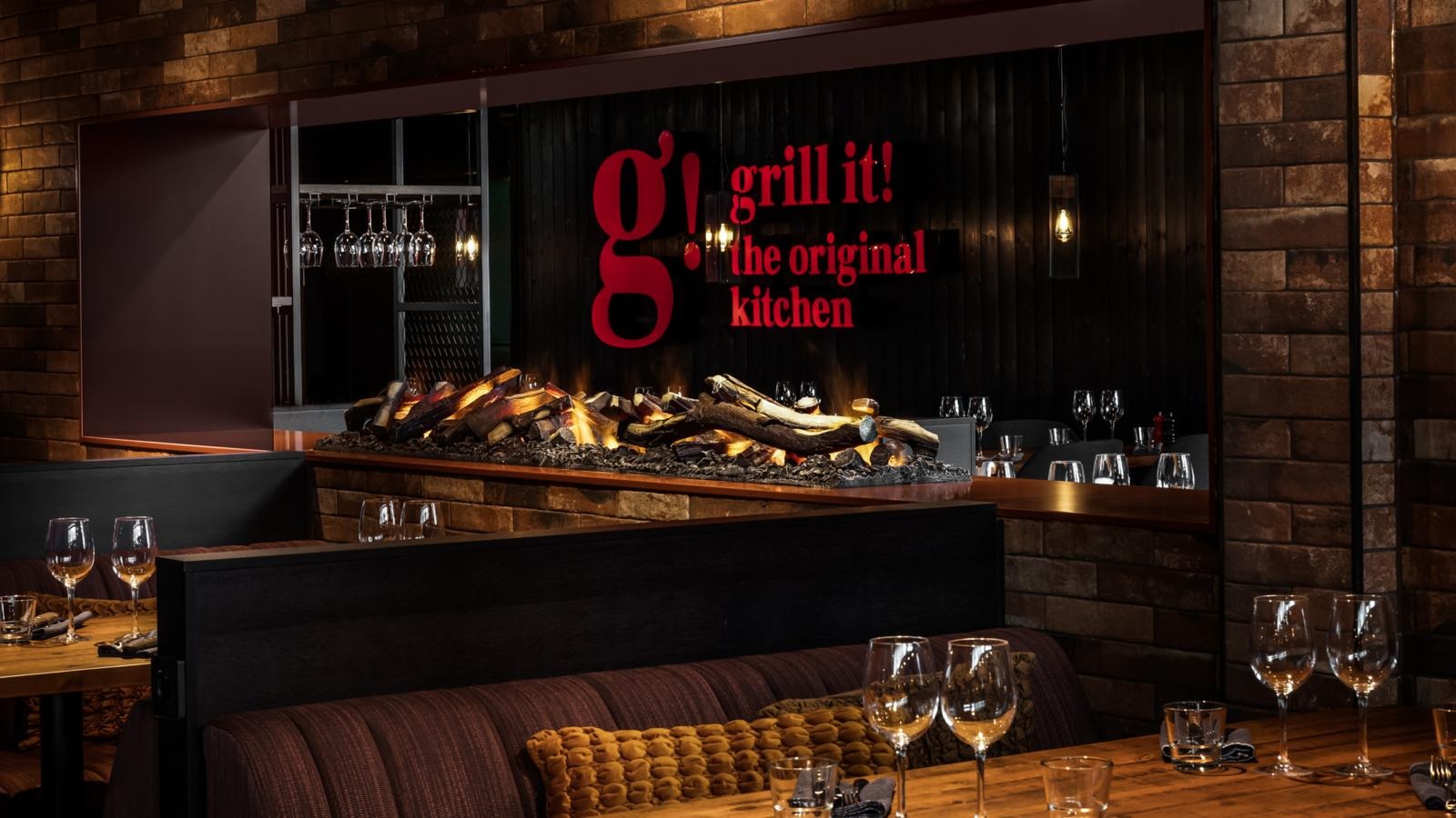 Ravintolan seinällä olevaa punaista Grill it! logoa koristaa tuli hiilineen.