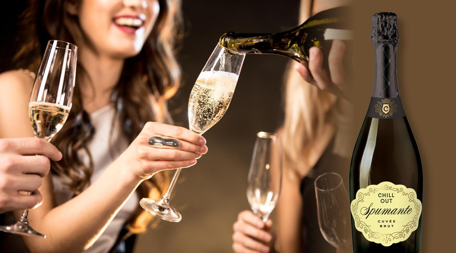 Naisia kuohuviinilasit kädessä. Yhteen lasiin kaadetaan lisää pullosta ja sitä pitelevä nainen hymyilee.