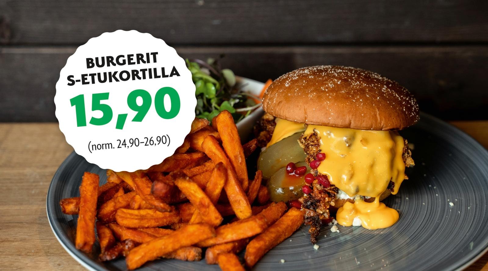 Juustohampurilainen, bataattiranskalaiset ja salaattia kulhossa.