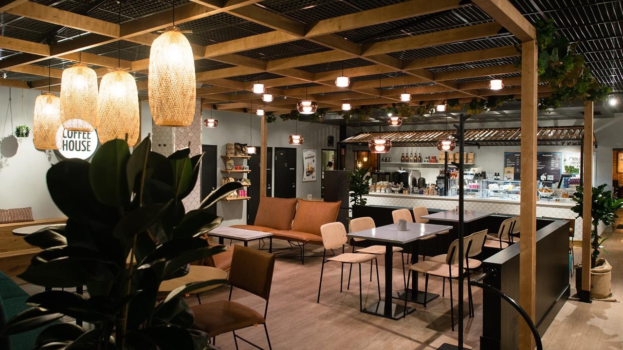 Coffee Housen sisustus on jaoteltu viihtyisiksi alueiksi, joissa valaisimet, kasvit ja puun sävyt luovat rauhallisen tunnelman.