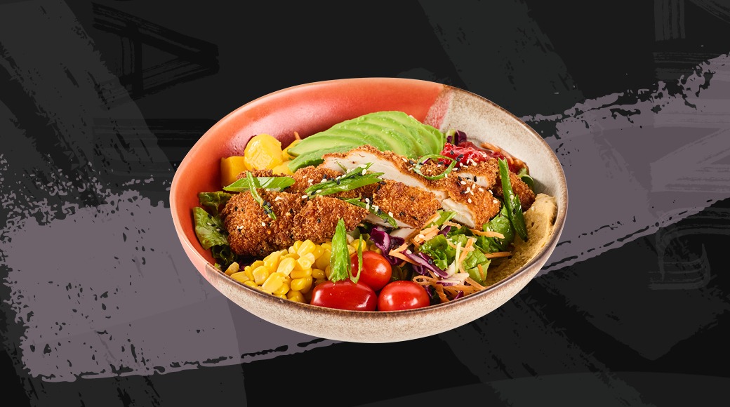 Salad bowl with breaded chicken, avocado, corn, cherry tomatoes and mixed greens.