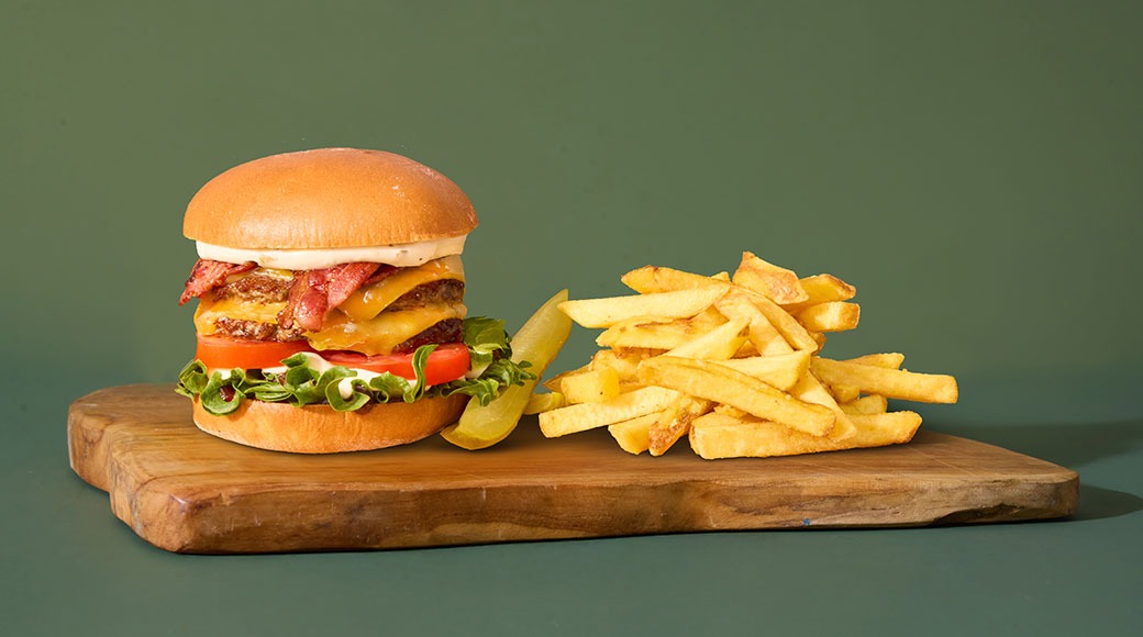 Briossisämpylä, kaksi burgerpihviä, cheddarjuustoa, pekonia, Amarillon tulista savu-nagakastiketta, jalapeno-valkosipulimajoneesia, salaattia, tomaattia ja suolakurkkua. Tarjoillaan ranskalaisten kera.