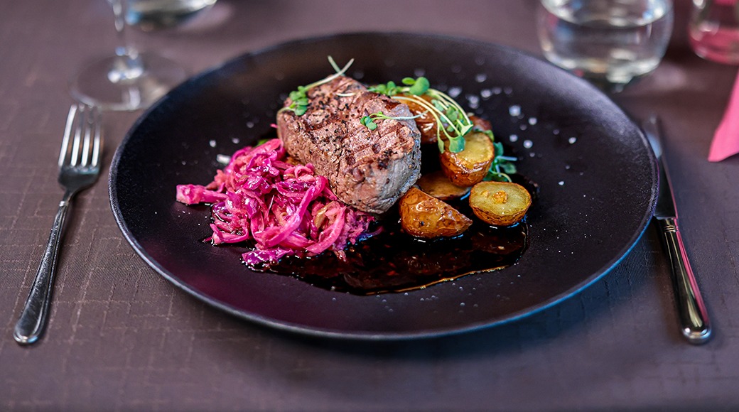 Naudan sisäfilee 150 g, tummaa valkosipulikastiketta, kaalipaistosta sekä paahdettua perunaa.