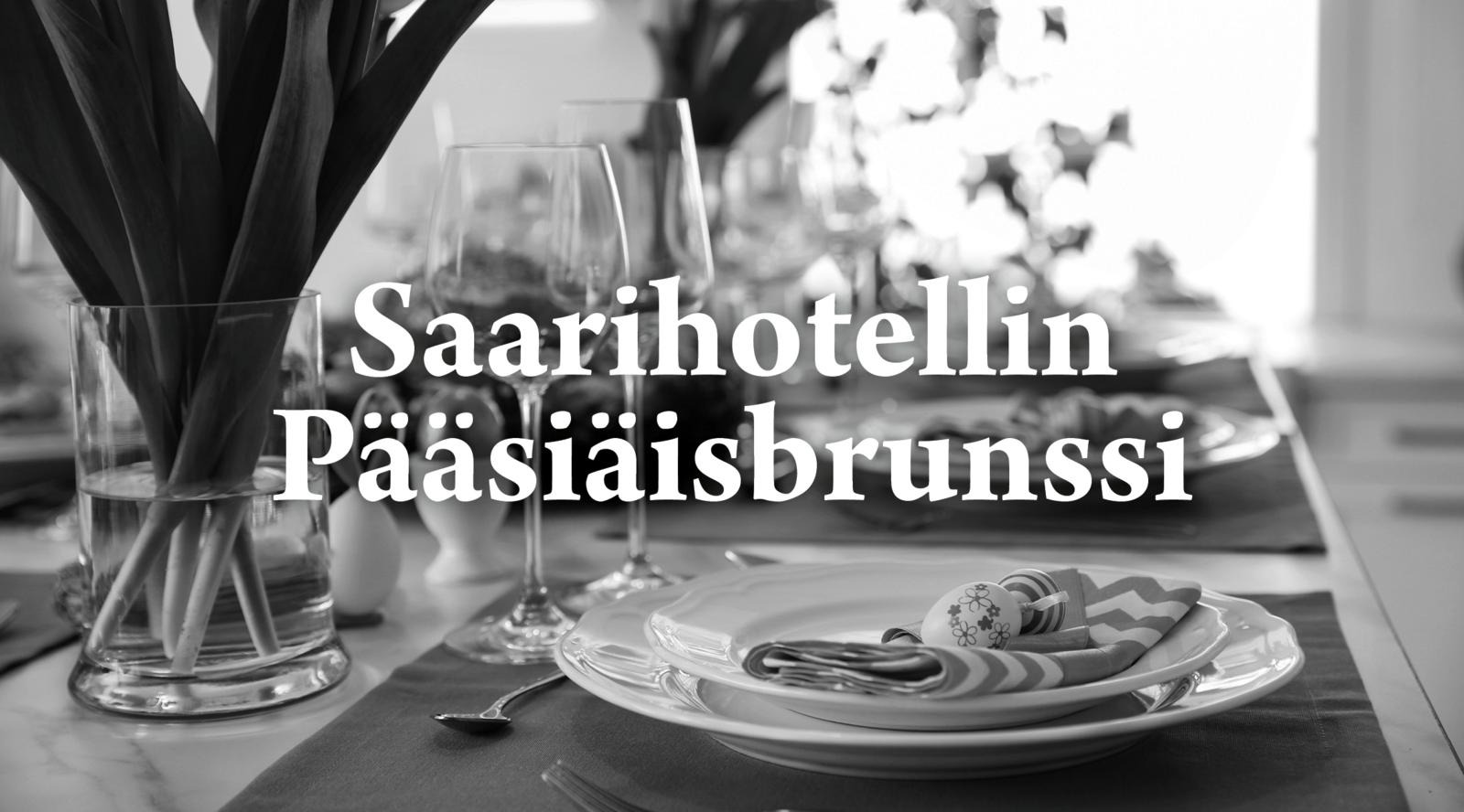 Mustavalkoinen kuva pääsiäisteemalla katetusta pöydästä.