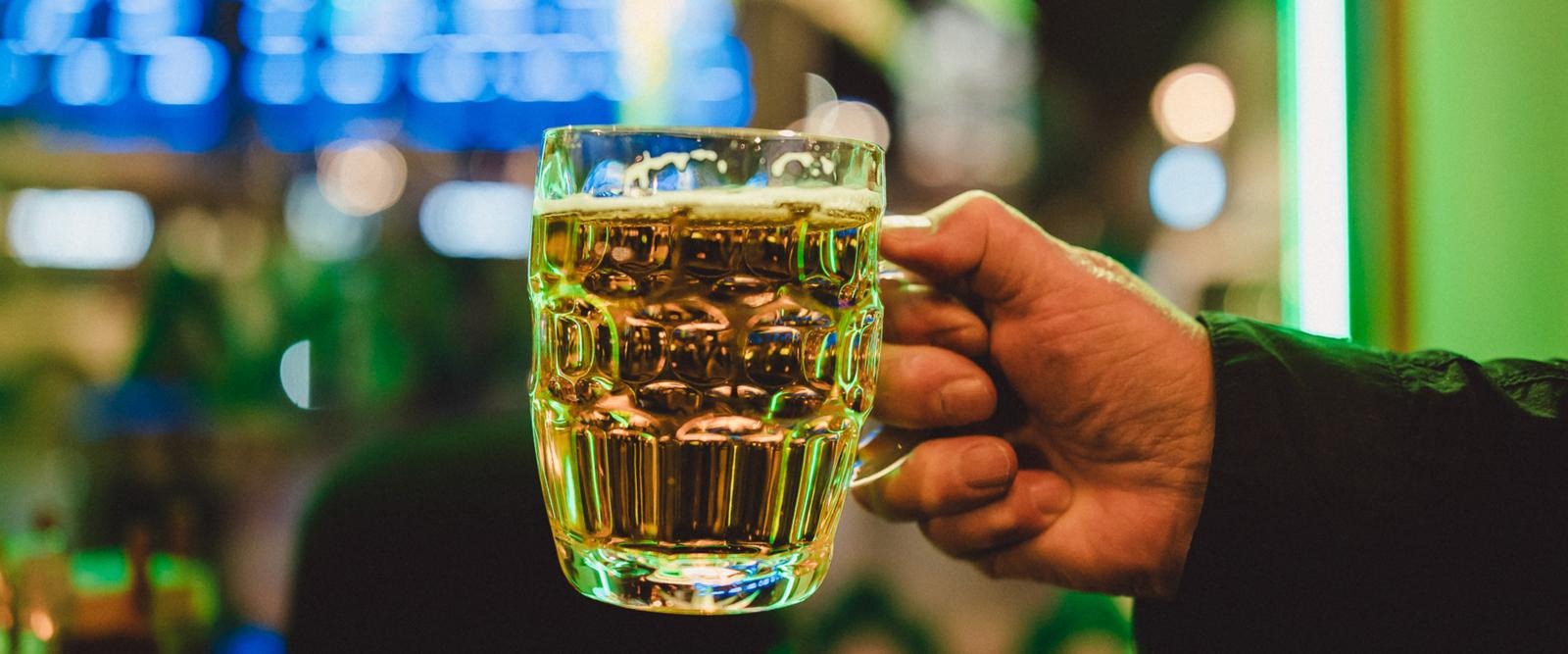 Miehen käsi pitää täyttä oluttuoppia Pub Hovipojassa