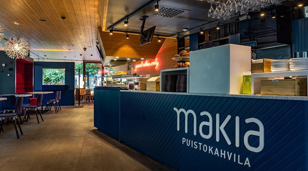Kahvilan tummansininen palvelupiste, jossa lukee valkoisella makia puistokahvila.