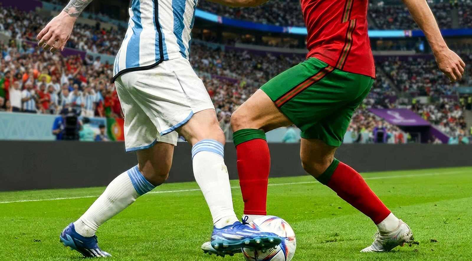 Kaks jalgpallurit võistlevad palli pärast staadioni muruväljaku peal täis tribüünide ees.