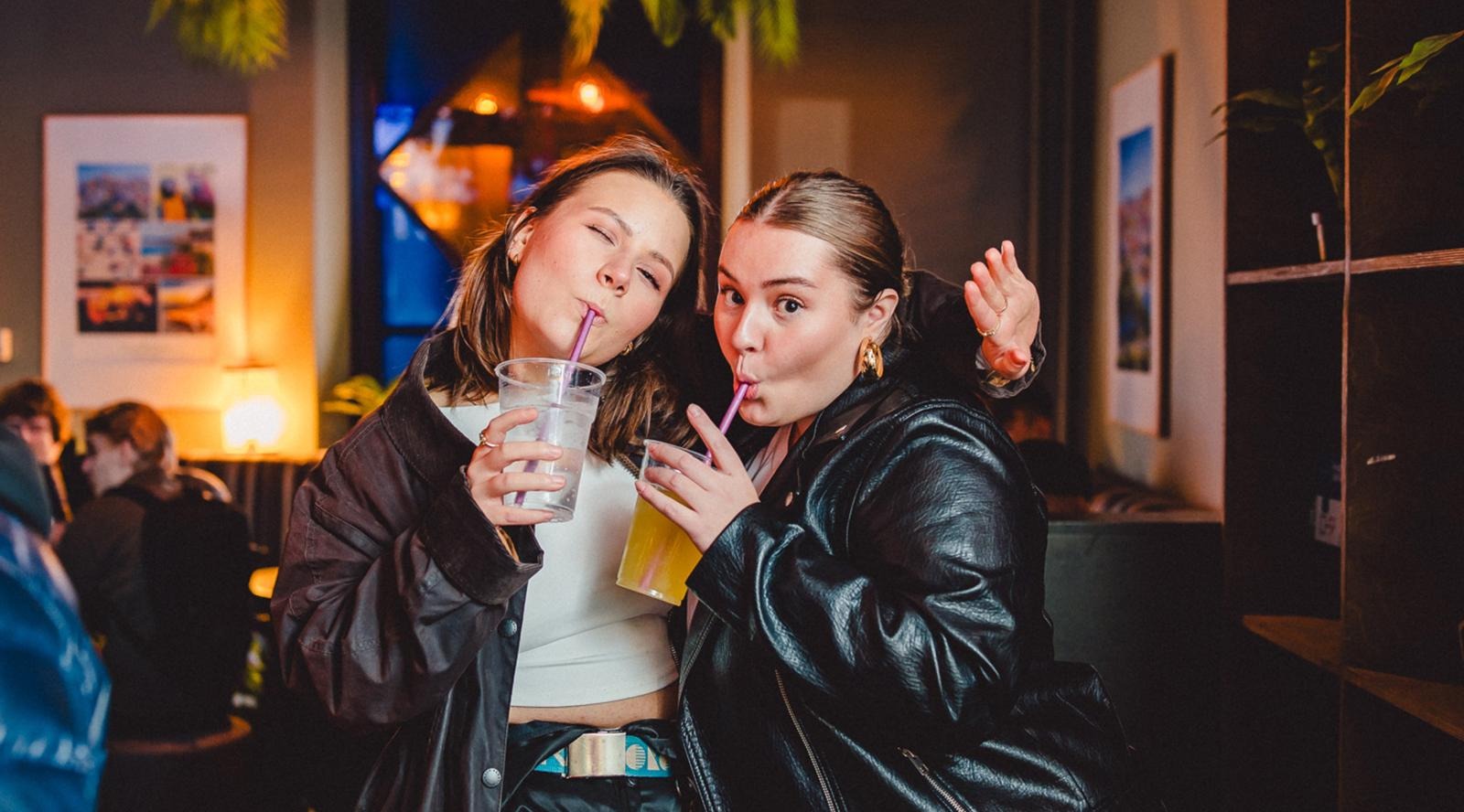 Kaksi nuorta naista juomassa alkoholijuomia Tampereen Las Palmas karaokebaarissa