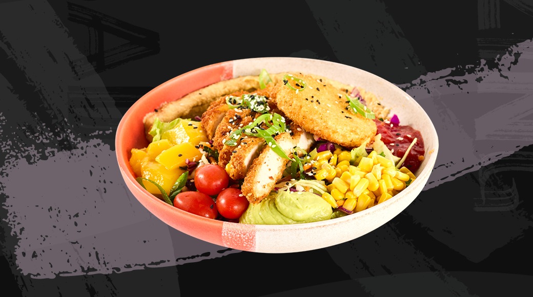 Bowl with colorful salad featuring fried chicken, cherry tomatoes, corn, avocado and cheese toast.