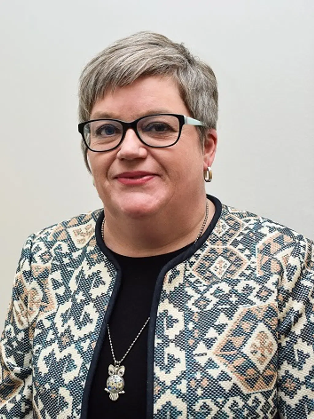 Nainen katsoo kameraan hymyillen