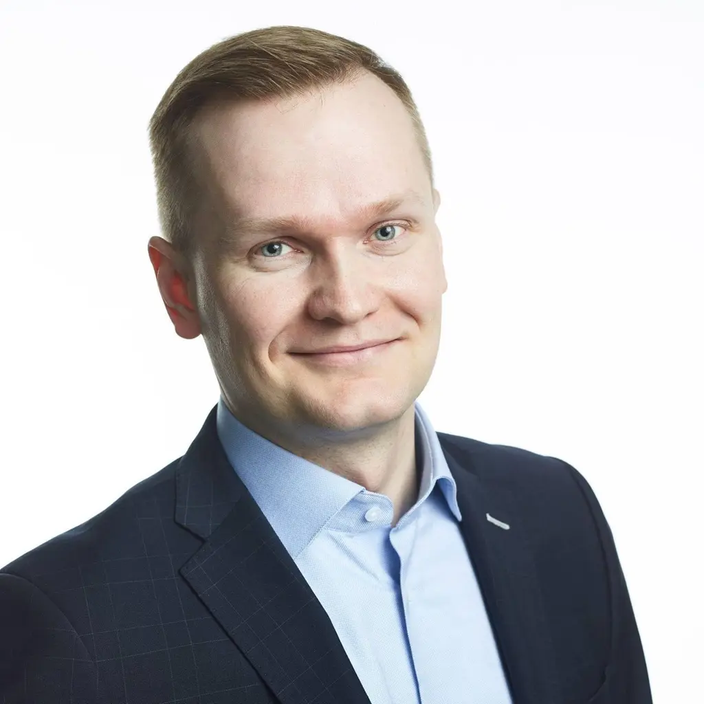 Mies katsoo kameraan hymyillen