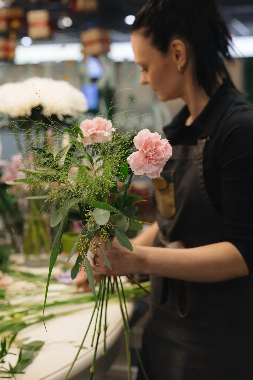 Floristi kokoaa kukkakimppua