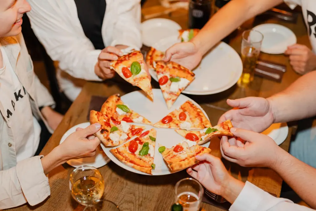 Ihmiset jakavat pizzan Rossossa.