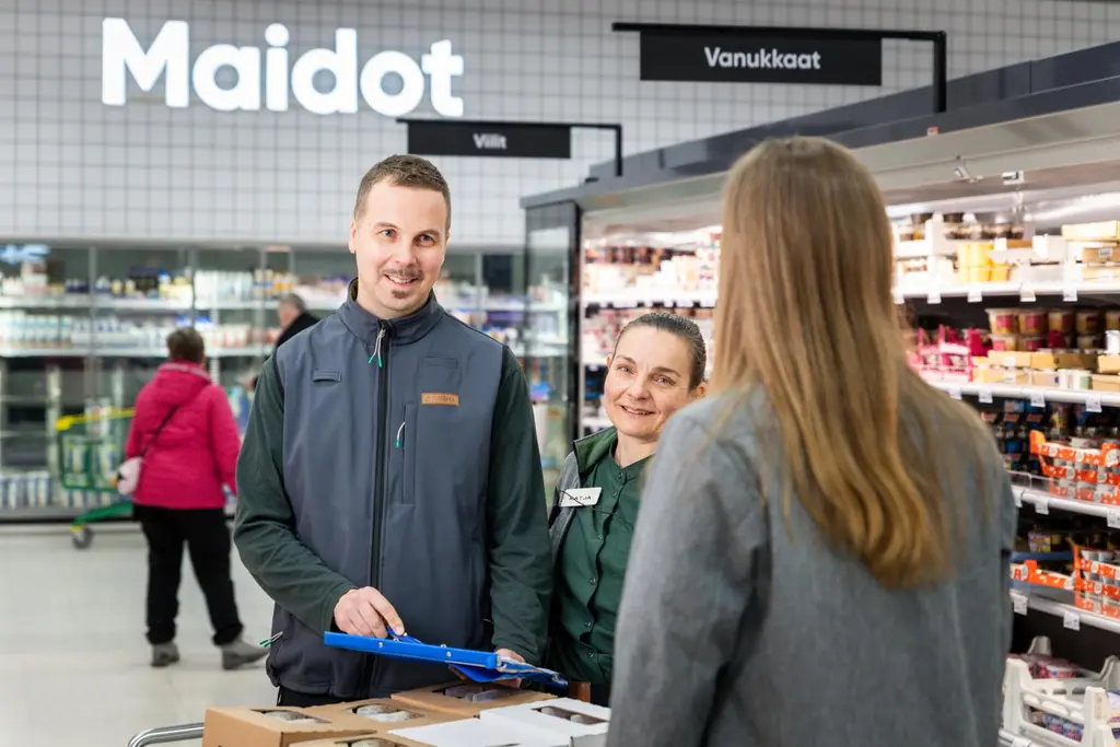 S-marketin työntekijäkolmikko hyllyttää kylmätuotteita.