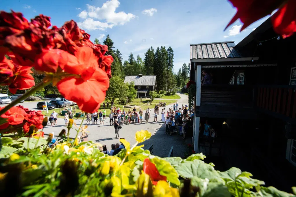 Bomban talon edessä iso väkijoukko aurinkoisessa kesäsäässä.