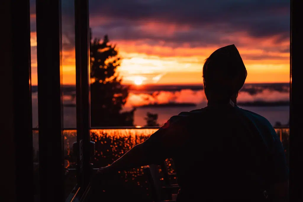 Ihminen ihailemassa auringonnousua Break Sokos Hotel Kolin terassilta.