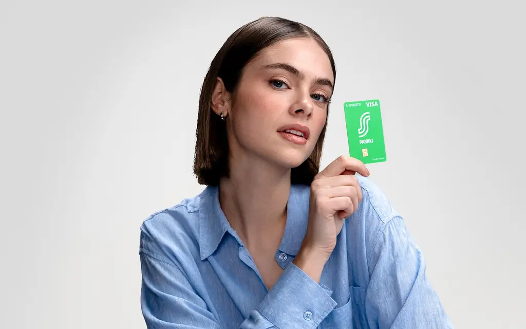 Nainen pitelee kädessään S-Etukorttia.