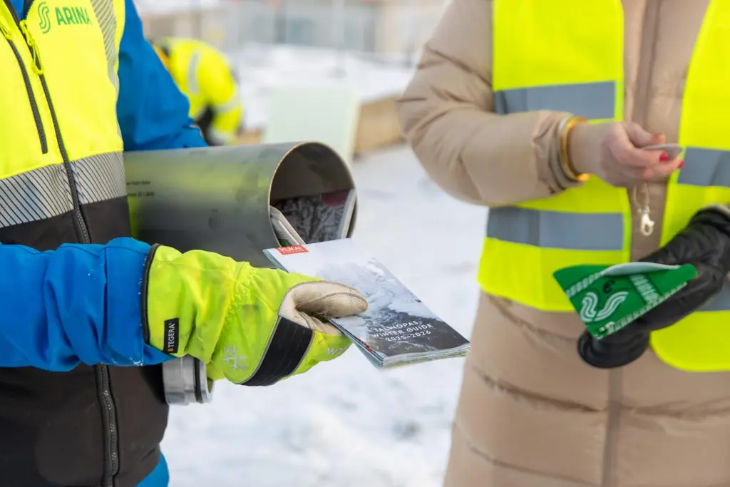 Henkilöt rakennustyömaalla täyttävät metallista kapselia.