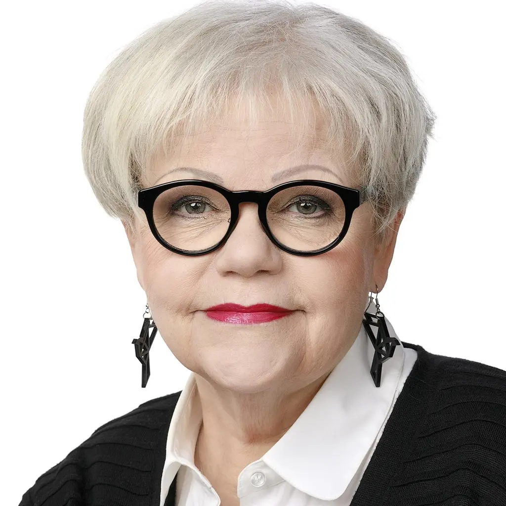 Nainen katsoo kameraan hymyillen