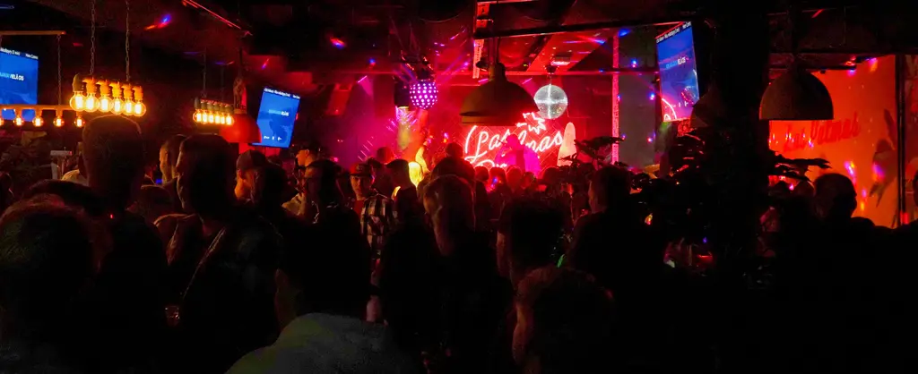 Las Palmasissa ihmisiä juhlimassa hämärässä tanssisalissa.