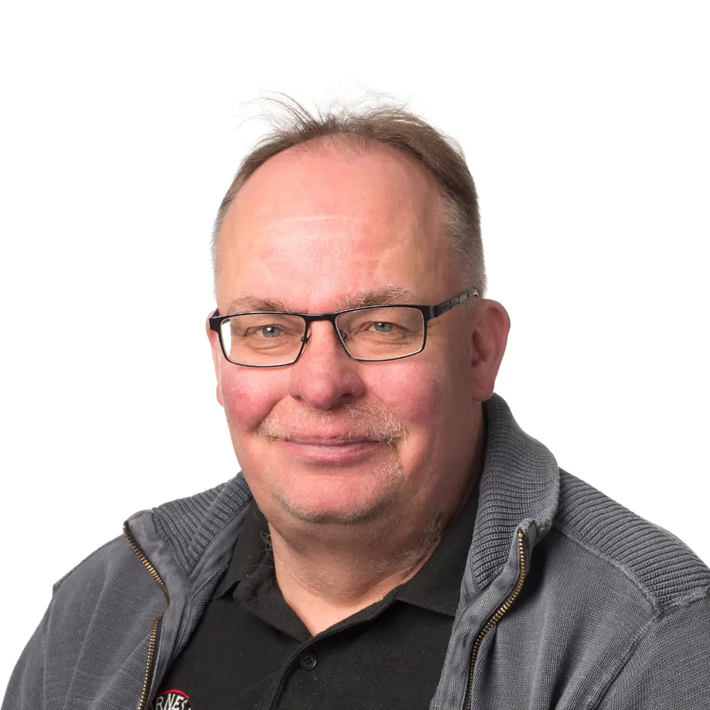 Mies katsoo kameraan hymyillen