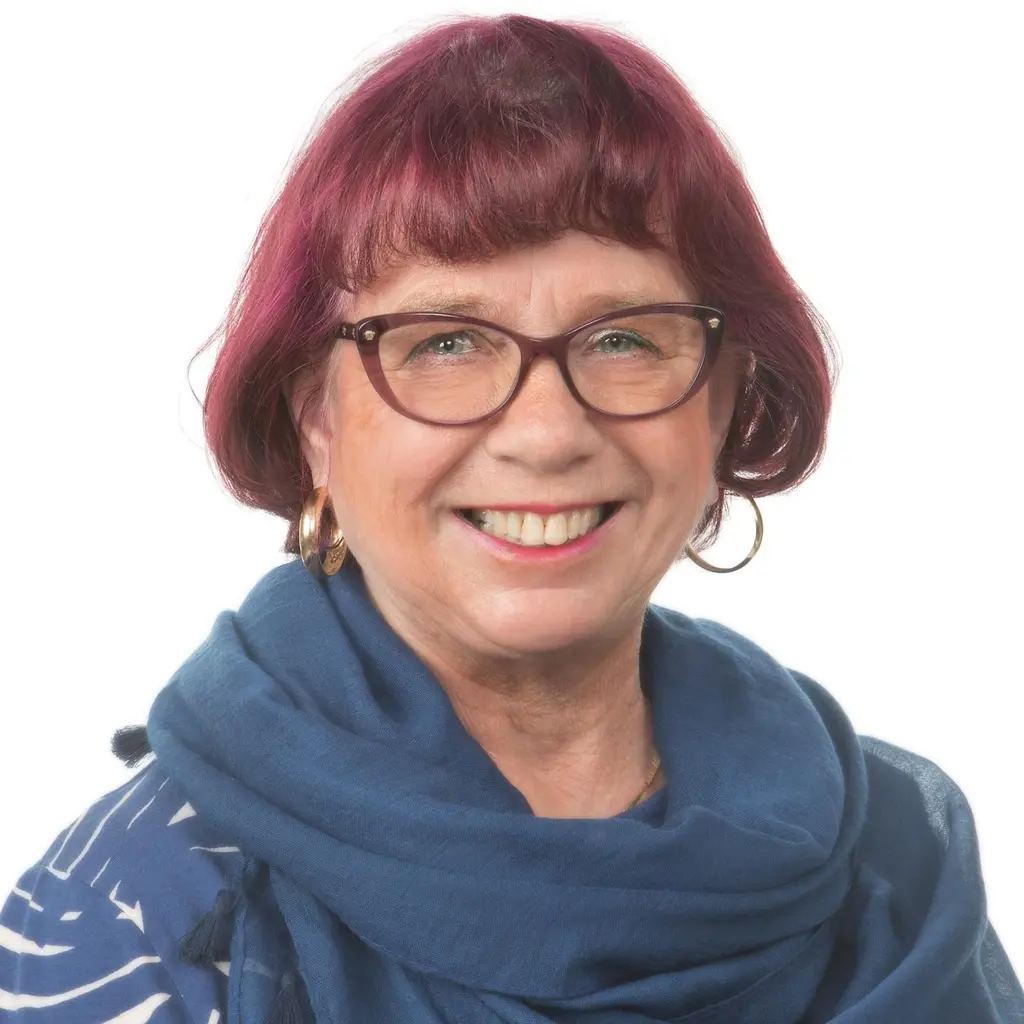 Nainen katsoo kameraan hymyillen