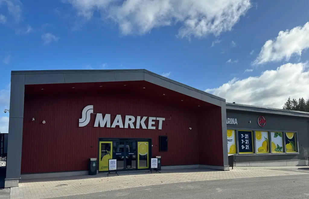 Punainen rakennus, jossa lukee "S-Market". Aurinkoinen päivä.