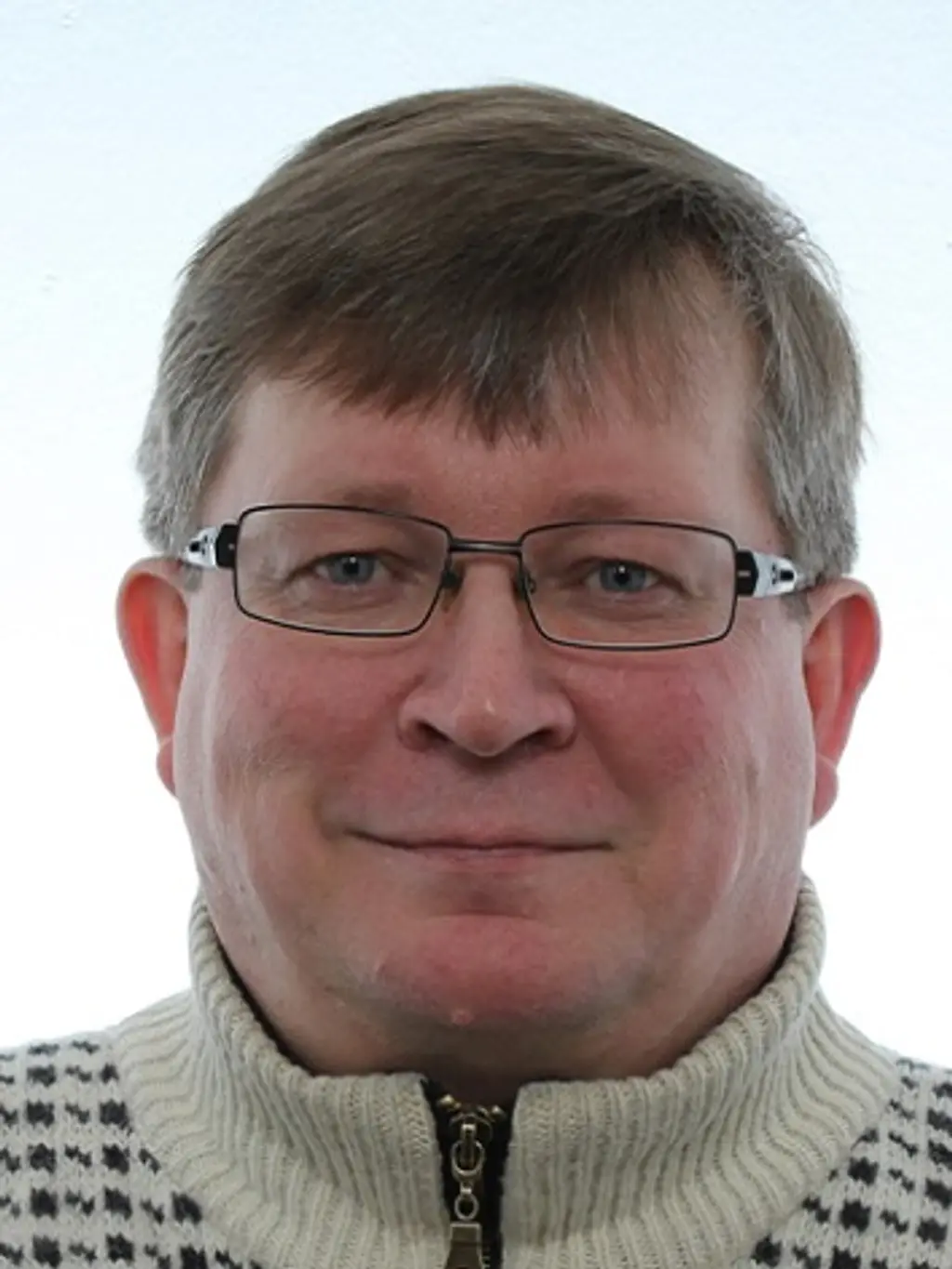 Mies katsoo kameraan hymyillen