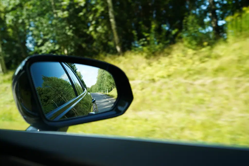 Vehreä kesämaisema auton ikkunasta