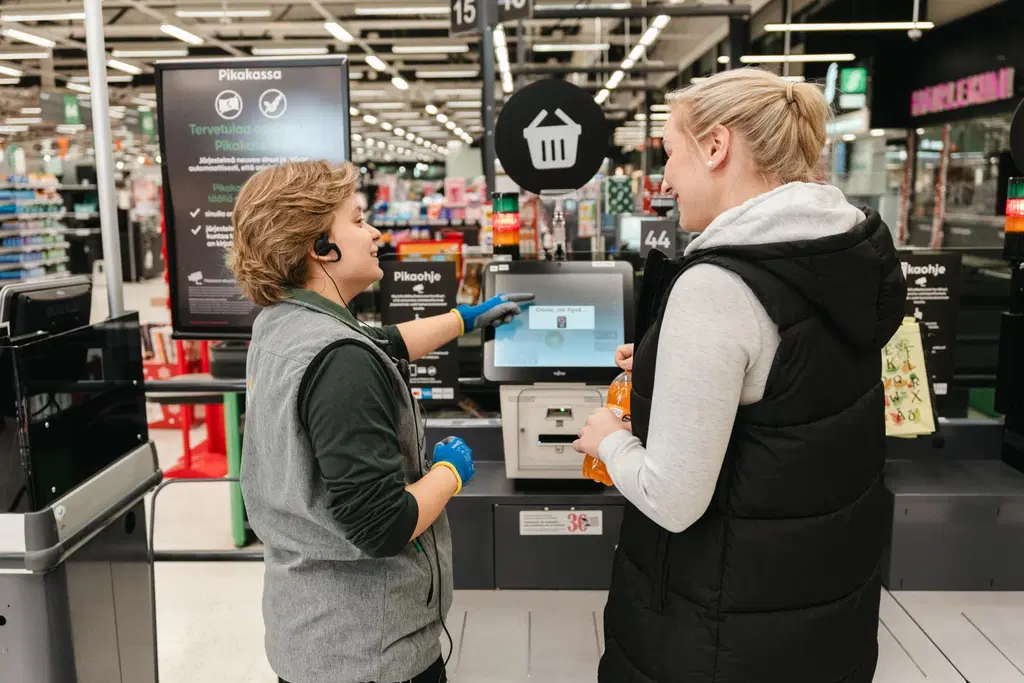 Myyjä auttaa asiakasta Prisman pikakassalla.