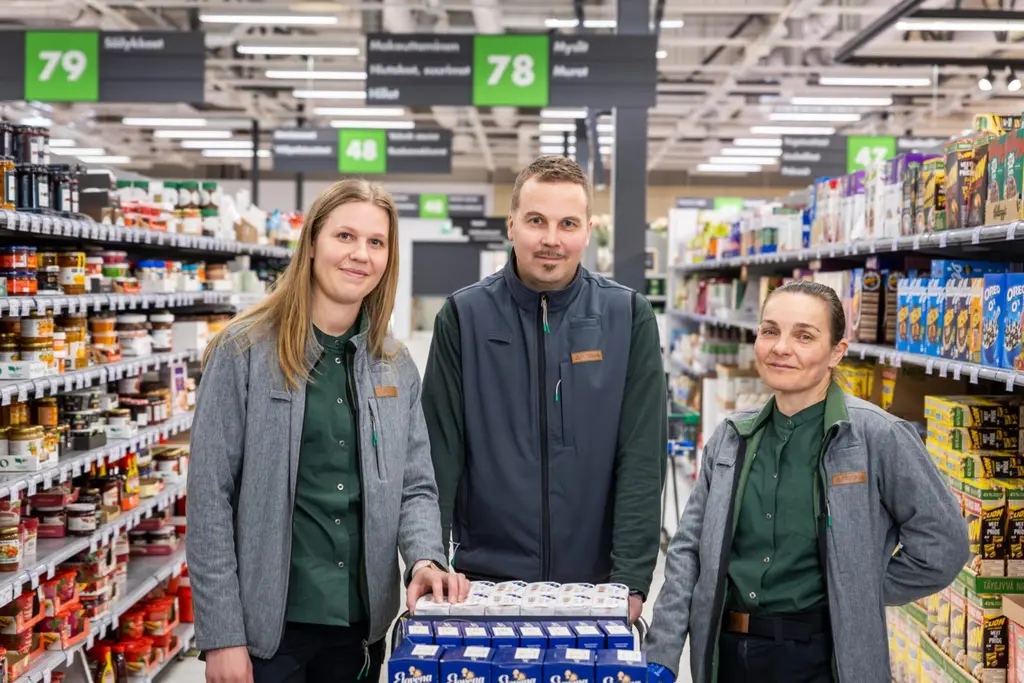 Kolme työntekijää hymyilee kameralle.