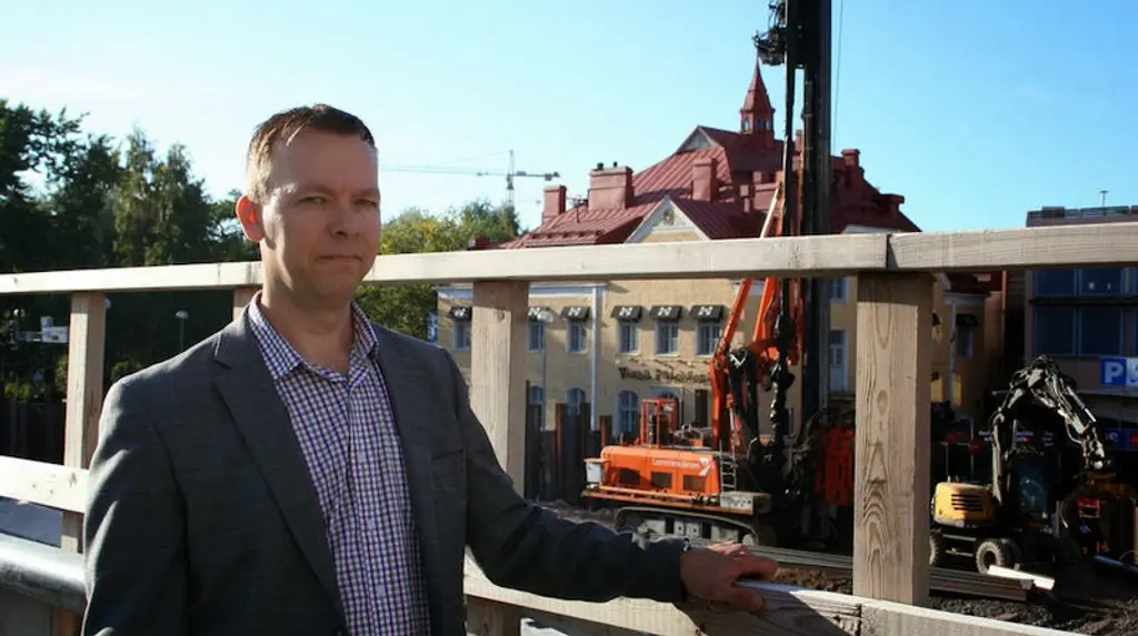 Mies seisoo rakennustyömaan edessä