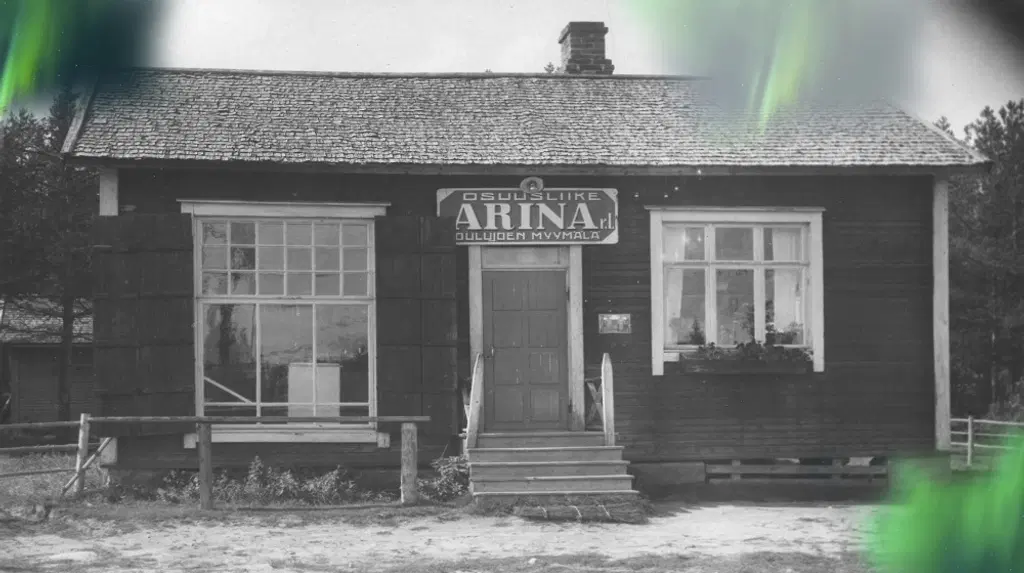 Mustavalkoinen kuva Oulujoen myymälästä vuodelta 1917. Kuvassa on vihreä revontuliefekti.