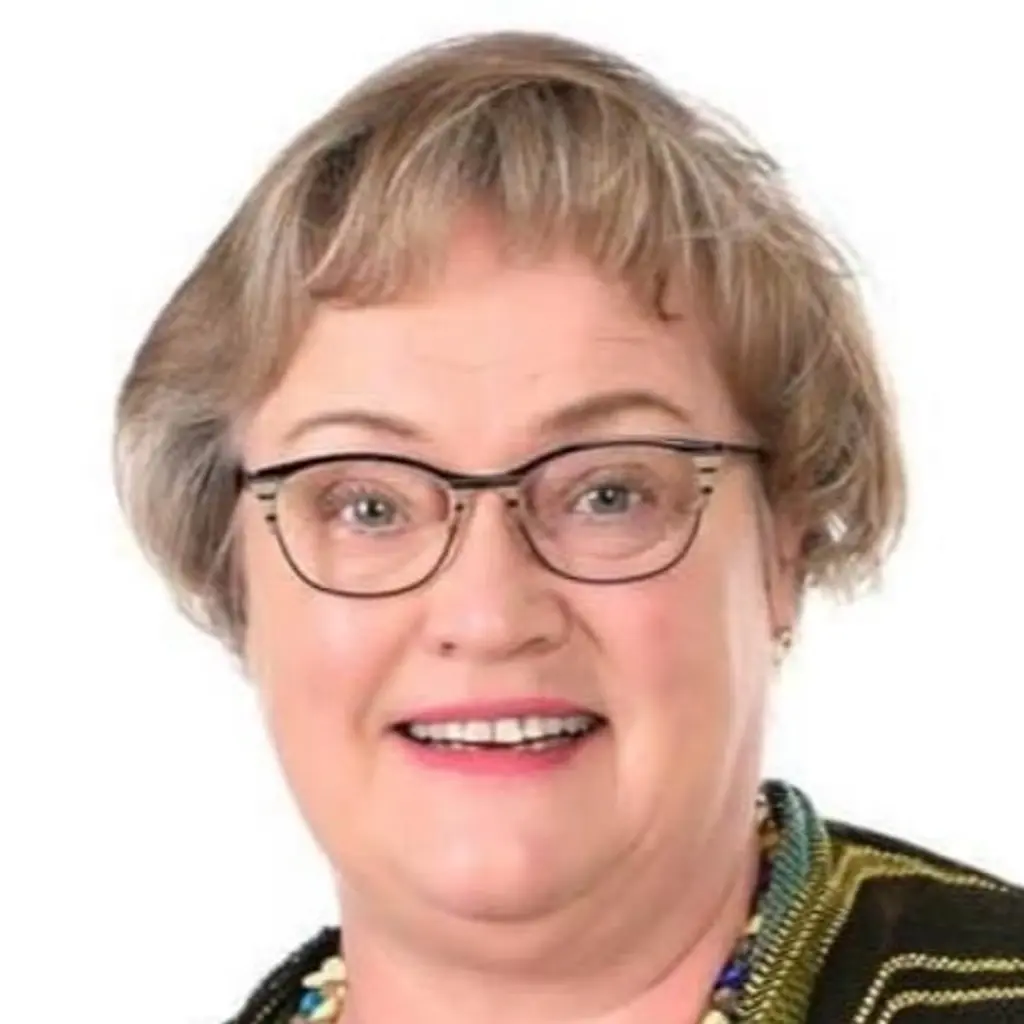 Nainen katsoo kameraan hymyillen