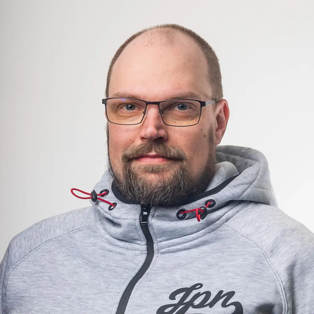 Mies katsoo kameraan hymyillen