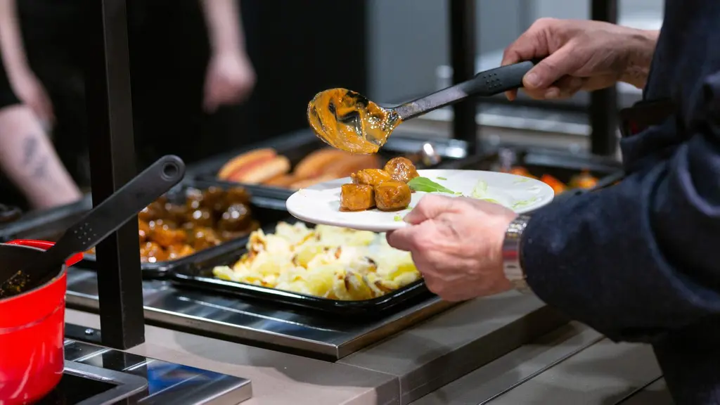 Asiakas ottaa lihapullia lounasbuffassa.