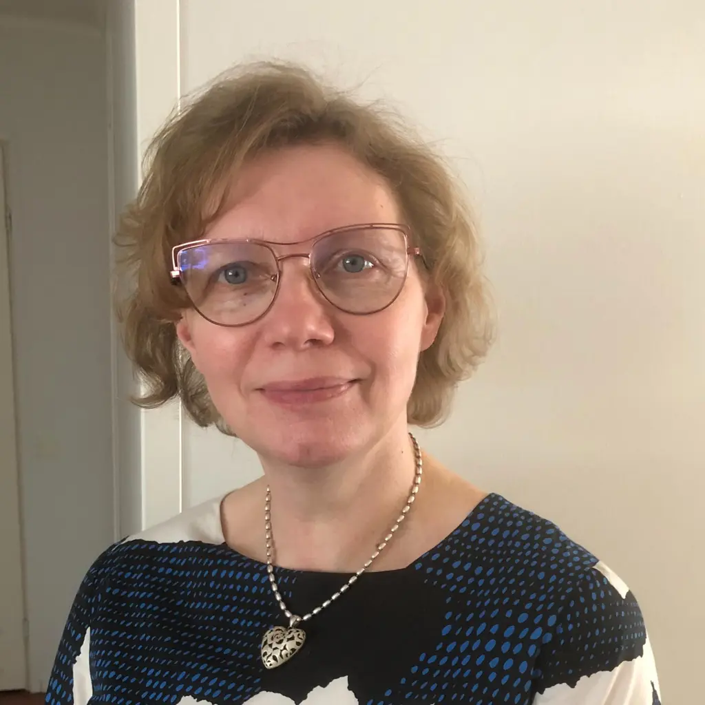 Nainen katsoo kameraan hymyillen