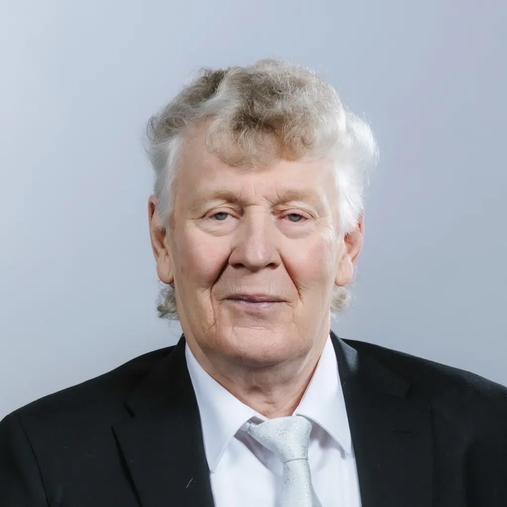 Mies katsoo kameraan hymyillen