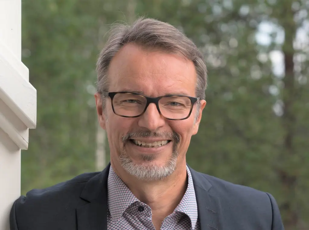 Mies katsoo hymyillen kameraan